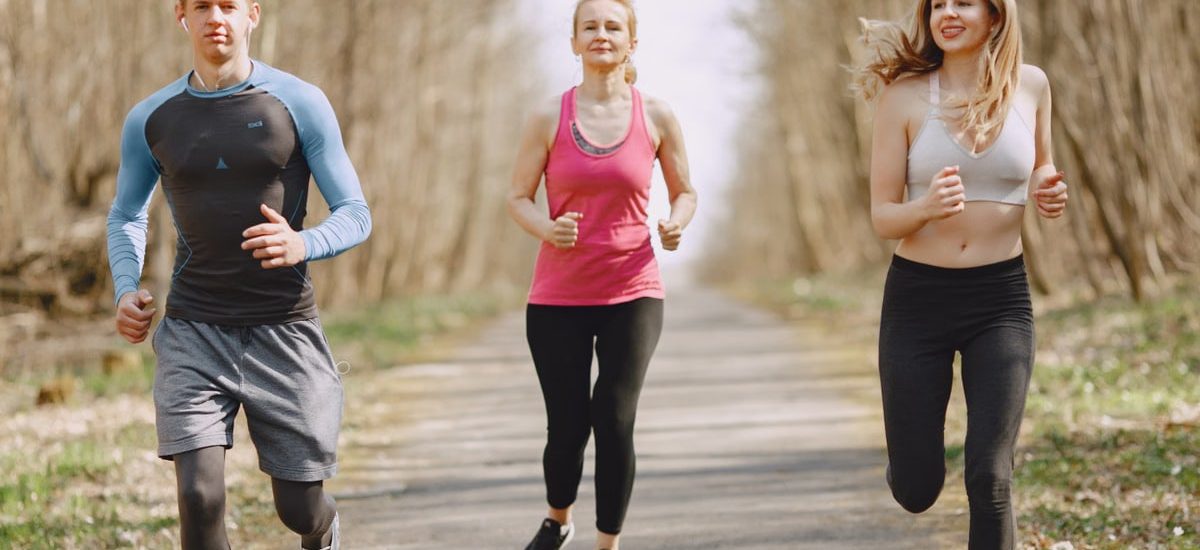 Three adults jogging on a park path, embracing a healthy and active lifestyle.